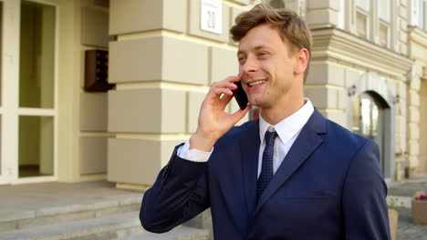 Retrato-De-Un-Hombre-Ejecutivo-Usando-El-Teléfono-En-La-Calle.-Hombre-Sonriendo-Con-Teléfono-Afuera