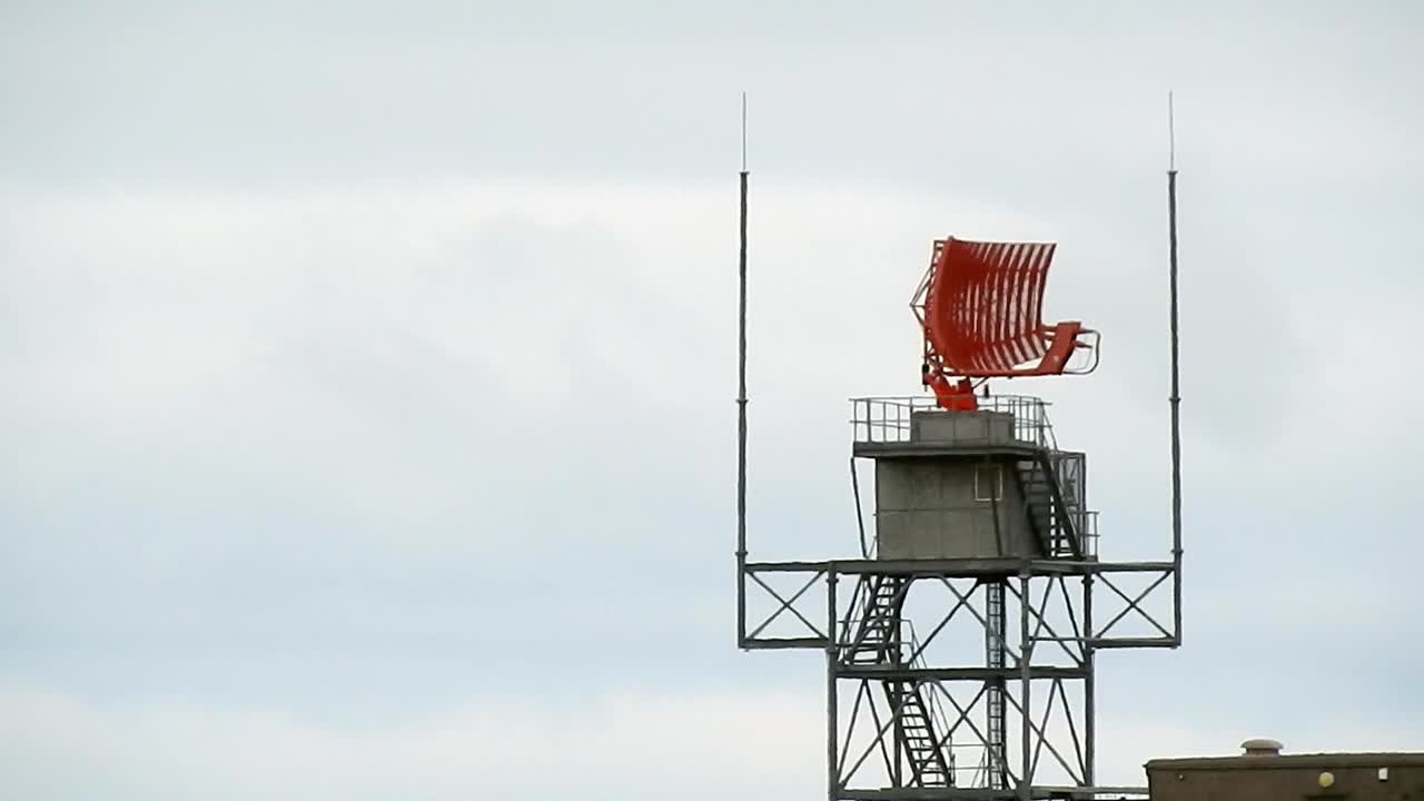 Air traffic control radar tower rotating across Welsh valley airport in Holyhead aerodrome