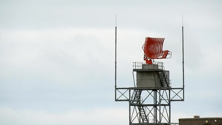 Air traffic control radar tower rotating across Welsh valley airport in Holyhead aerodrome