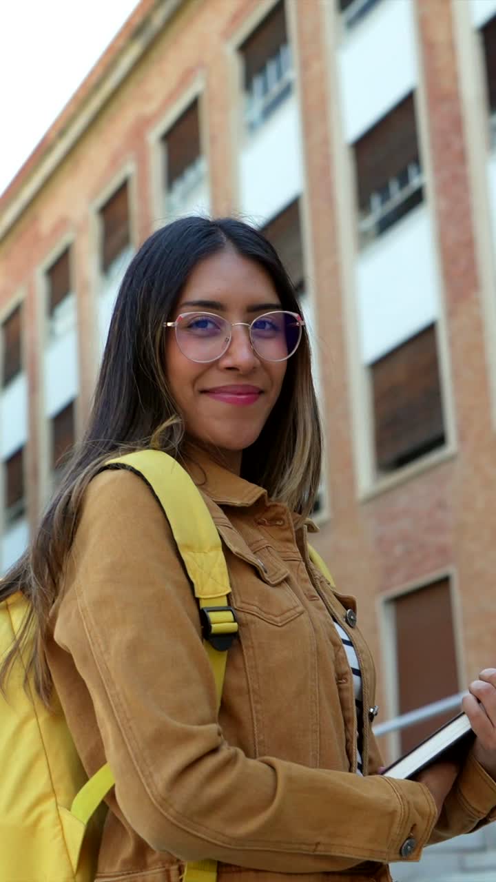 estudiante sonriente con mochila y libro