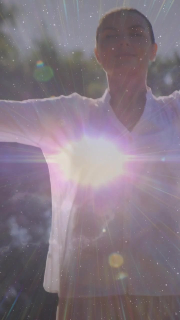Video verticale: Donna che alza le braccia per ricevere una luce di salute mentre appare un'orbita sul busto, creando stelle