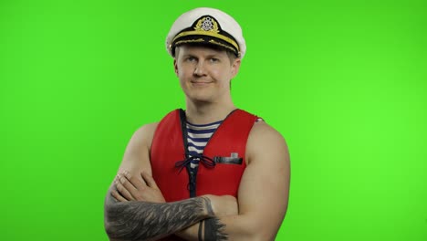 young muscular sailor man works as lifeguard at beach arms crossed. chroma key