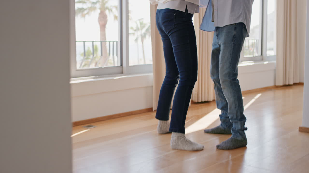 feliz pareja madura bailando en casa disfrutando de una relación exitosa divirtiéndose celebrando el aniversario de la jubilación
