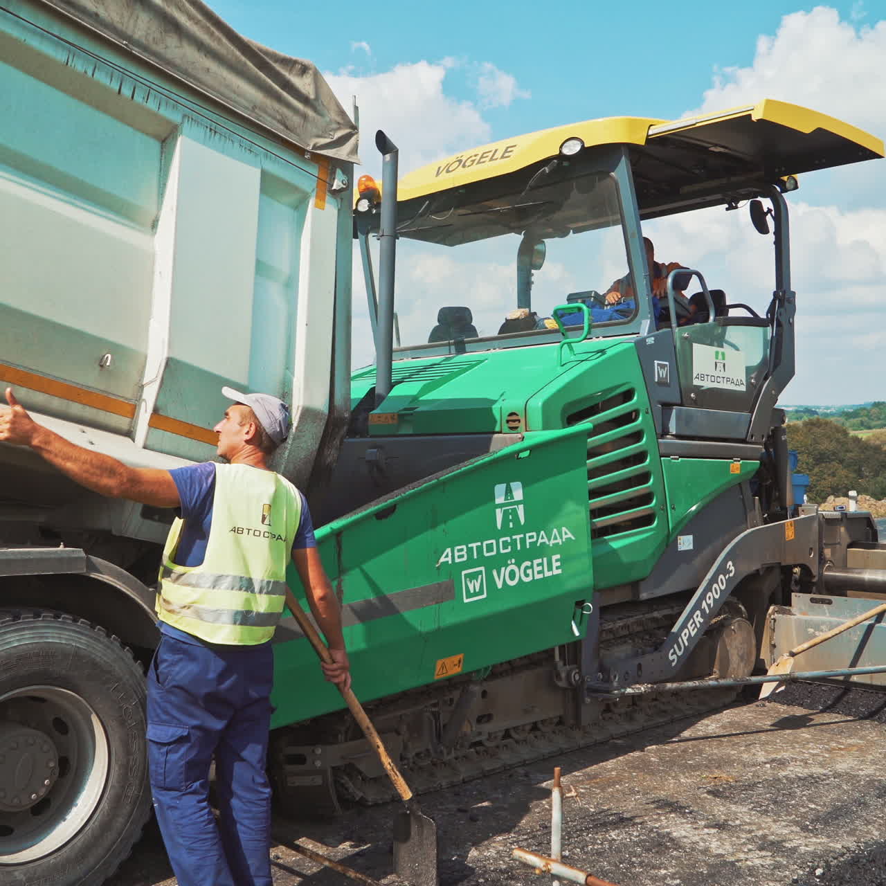 Industrial machinery on a road construction site. Roadworks at laying new asphalt. Paving machine laying fresh asphalt on a highway.