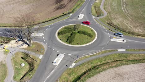 vista aérea de un vuelo tranquilo sobre una pequeña rotonda con carreteras del país y dos coches