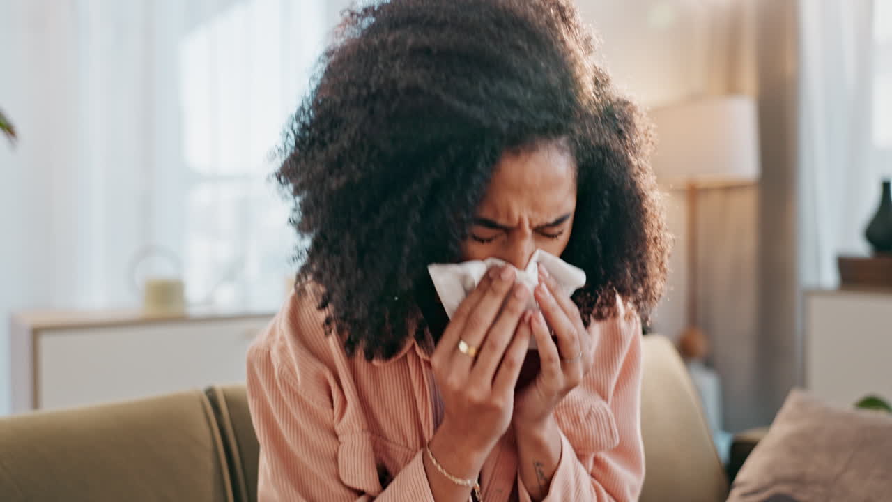 Woman blowing nose with tissue, feeling sick