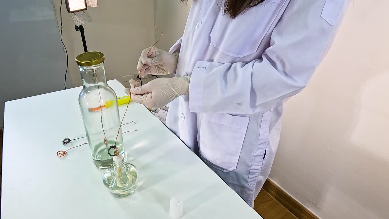 A scientist conducts a copper acetone oxidation reaction in a lab setting with controlled lighting and precise technique