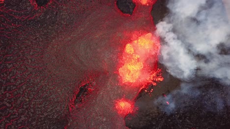 aerial top view over lava erupting in meradalir valley, from fagradalsfjall volcano, with smoke coming out