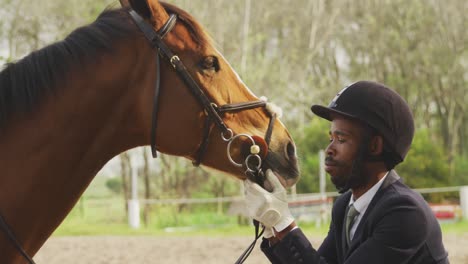 hombre afroamericano mirando a su caballo de doma