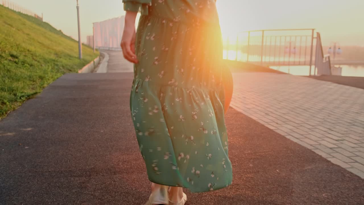 Woman in Green Dress with Hat at Sunset