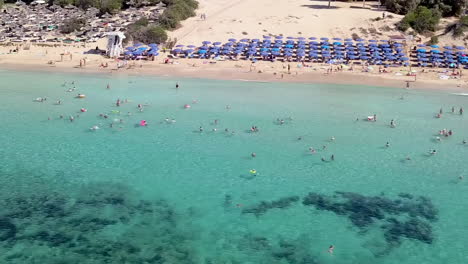 Aerial-view-of-a-holiday-resort-sandy-beach,-with-beach-umbrellas-and-sun-beds