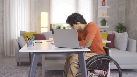 Disabled-young-man-sitting-in-wheelchair-making-video-call-with-laptop.