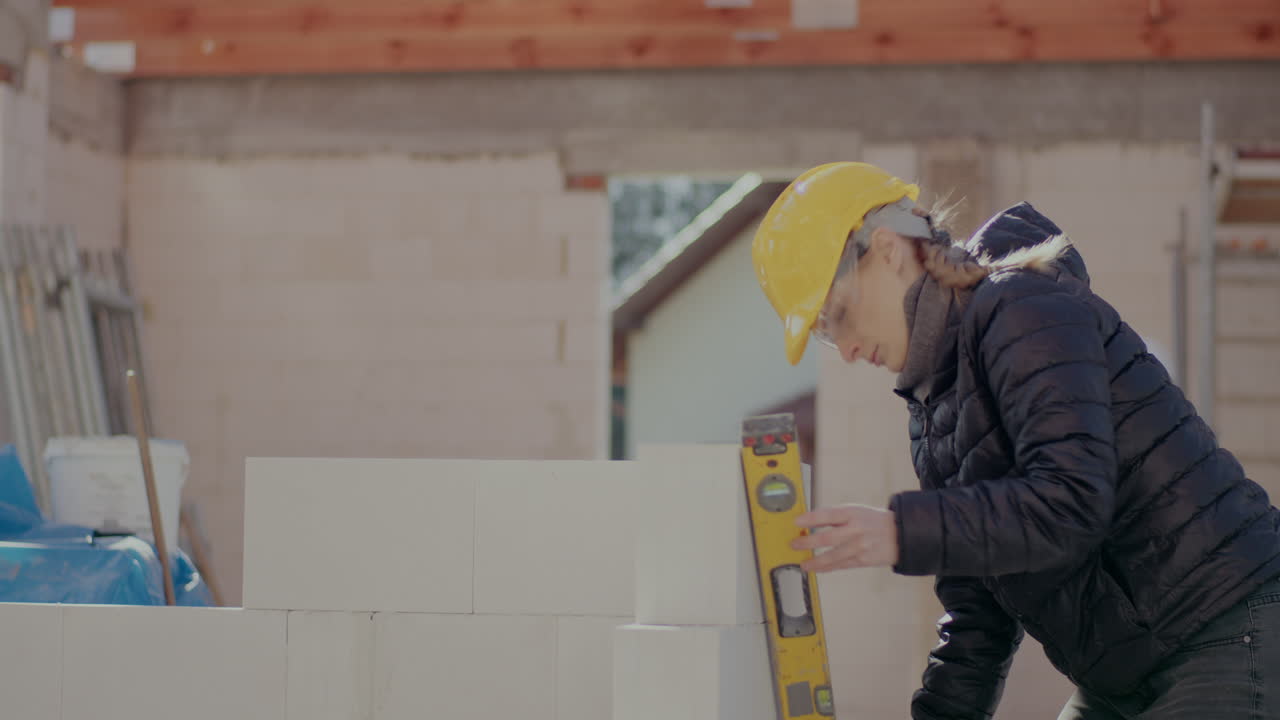 Lockdown shot of confident young female engineer analyzing concrete wall with level at construction site