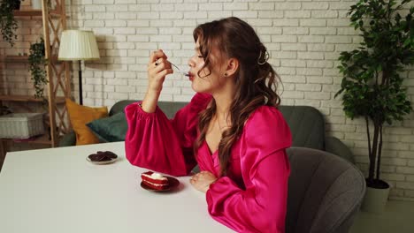 woman enjoying a slice of red velvet cake