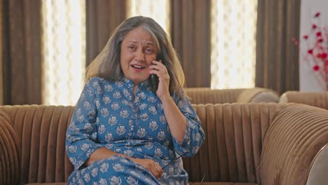 happy aged indian woman talking to someone on a phone call