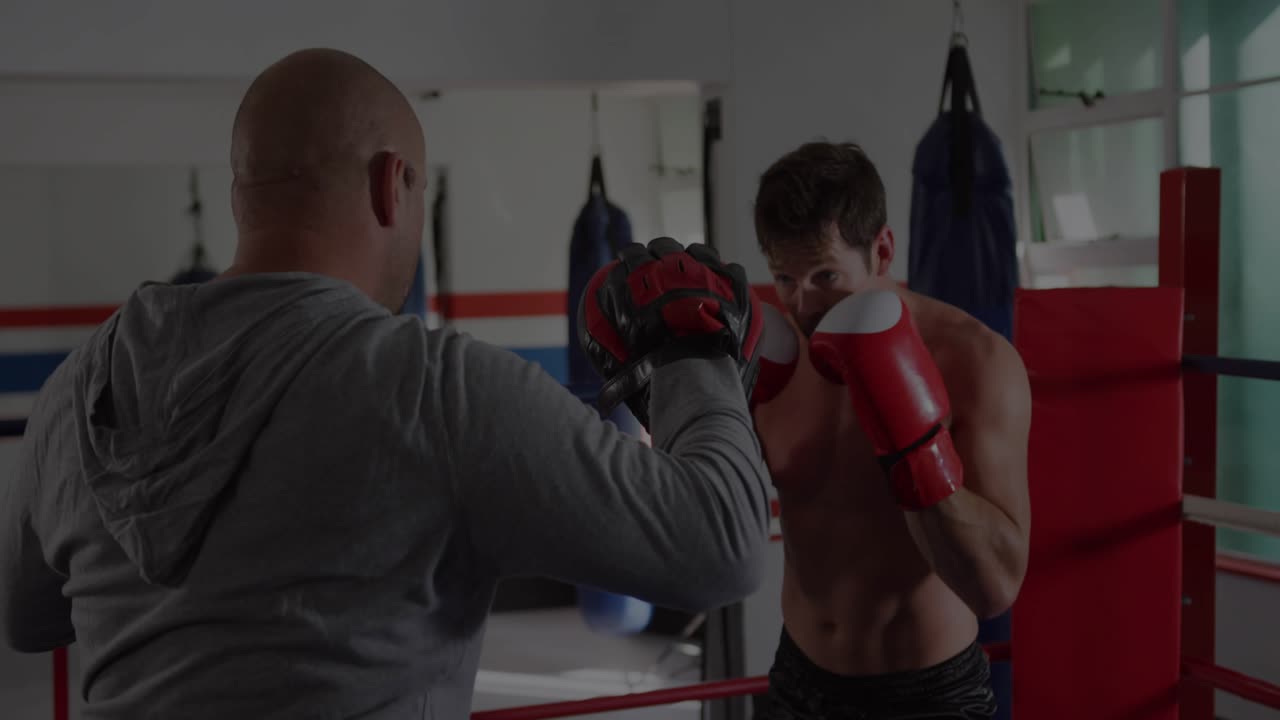 Coach raising focus mitts, boxer throwing red-glove combos and slipping, training boxing defense