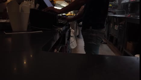 at the snack bar: orders being taken, fries being fried and different food being prepared for the client