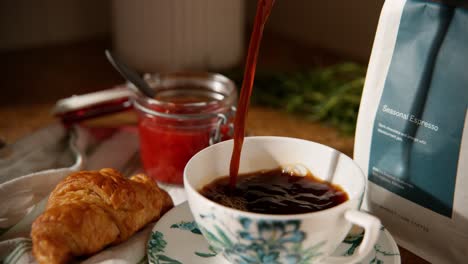 Kaffee-Am-Frühen-Morgen-Mit-Marmelade-Und-Croissant-In-Tasse-Gegossen-Natürliches-Licht-1000-Fps-Phantom