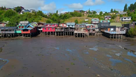 Coloridas-Casas-Sobre-Pilotes-De-Castro,-Vía-Fluvial-De-Castro,-Chile-Chiloe-4k-Panorámica-Aérea-Con-Drones