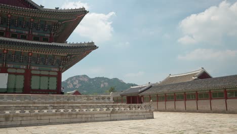 closeup of geunjeongjeon traditional building on summer sunny day, mountain hill in background in seoul, south korea