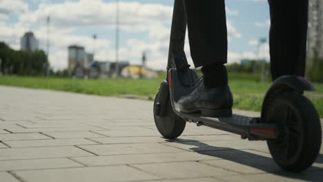 person riding an electric scooter on a city sidewalk