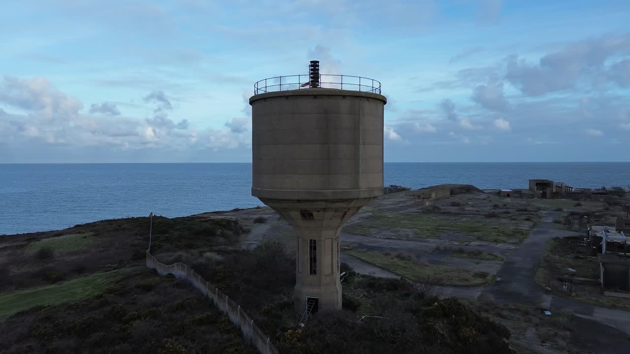 Vista aérea de uma instalação química Octel desativada, circulando a torre de água de uma fábrica industrial abandonada na costa