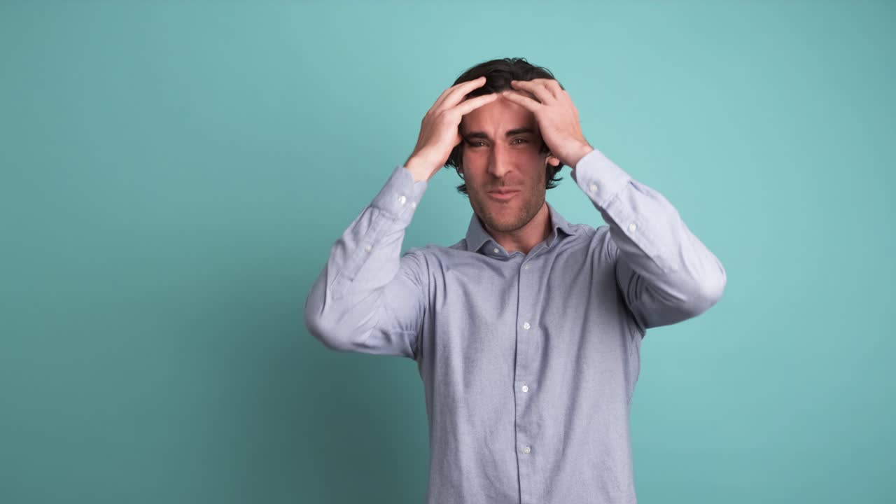 Successful adult man clenching fists in blue studio
