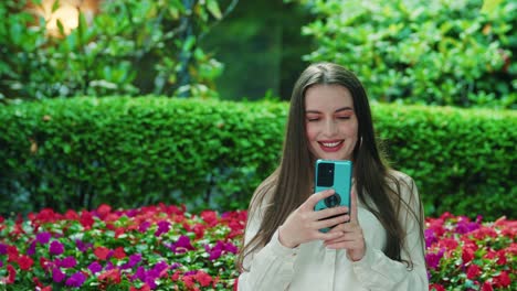 pretty-girl-using-mobile-phone-outside-then-smiling-from-what-she-sees