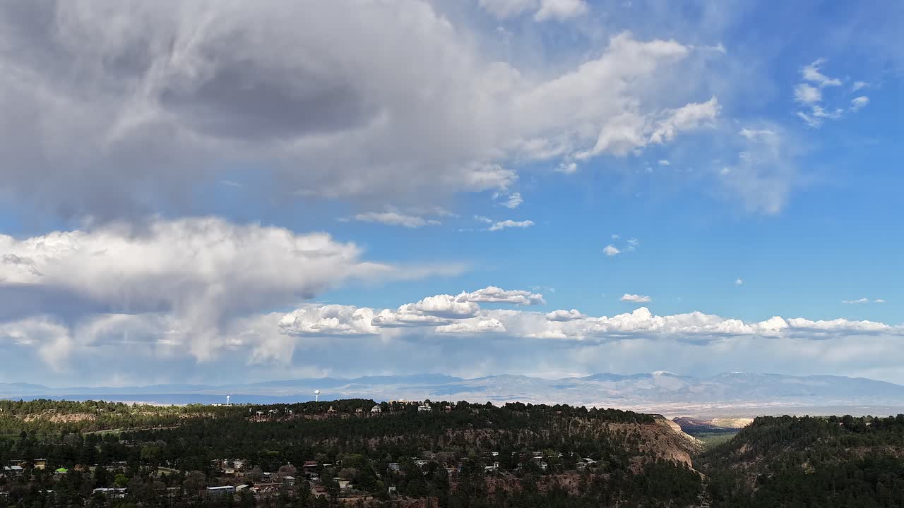 ニューメキシコ州ロスアラモスの高地風景上空を移動する劇的な雨雲を4Kドローンタイムラプスが捉える。パハリート高原上空の急速な大気の動きが荒々しい雰囲気を醸し出す。