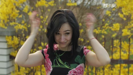 Attractive-young-woman-in-a-dress-with-flowers-making-funny-faces