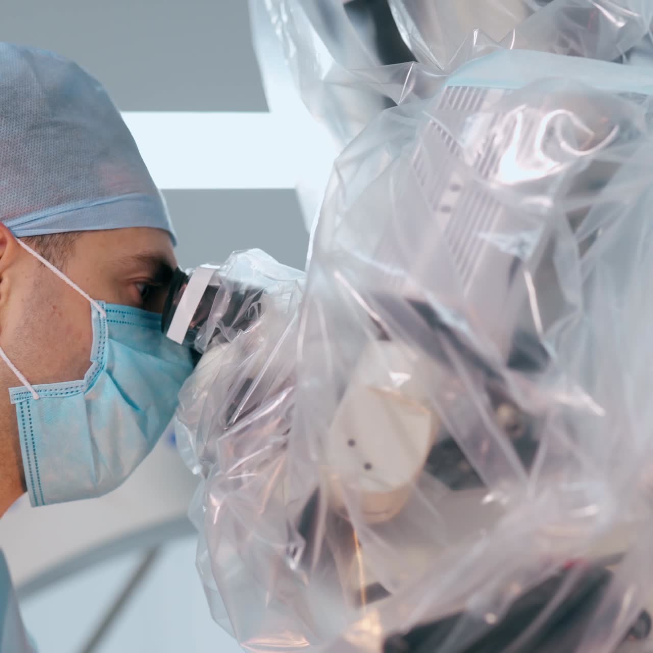 Side view of a doctor looking into microscope. Medical specialist perform a neurosurgery through the modern device.