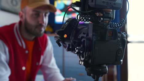 Filmmaker-holding-a-focus-wheel-and-testing-the-wireless-follow-focus-system-on-a-Canon-camera