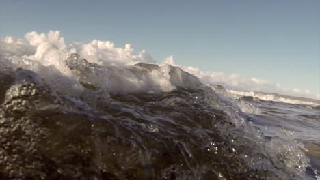 water level view of waves crashing and rolling into shore in slow motion 6