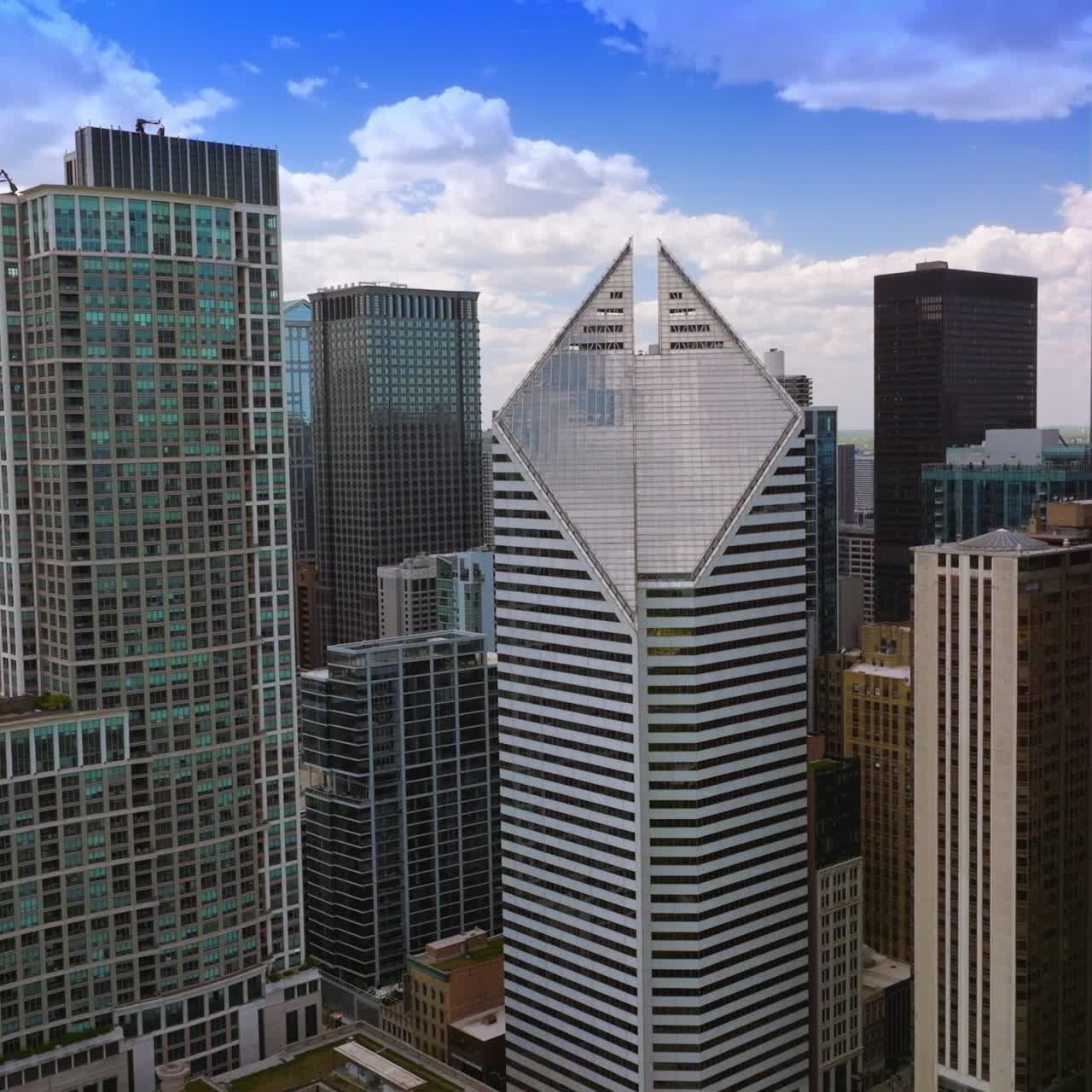 Flying among the beautiful diverse tops of amazing skyscrapers. Blue sky with white clouds at backdrop