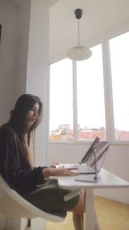 mujer trabajando desde casa en una computadora portátil