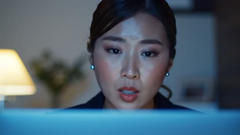focused woman engaged in deep concentration while speaking into a computer during a video call at night, emphasizing the importance of communication and connectivity