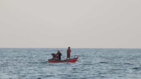 fishermen casting nets from a small boat.