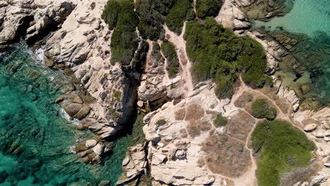 Steady-Aerial-drone-clip-over-a-rock-formation-in-an-exotic-beach-in-Vourvourou,-Chalkidiki,-Greece