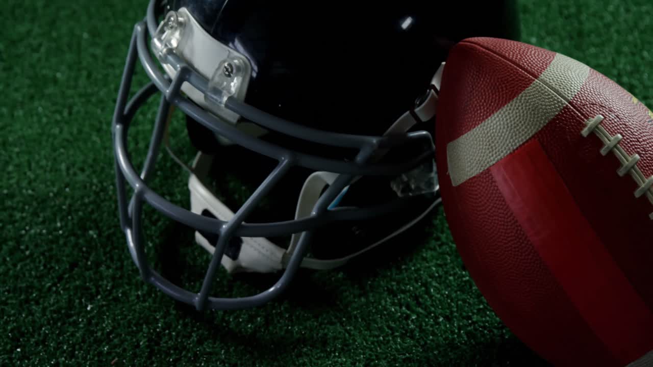 Pallone da football americano appoggiato sul casco 4k