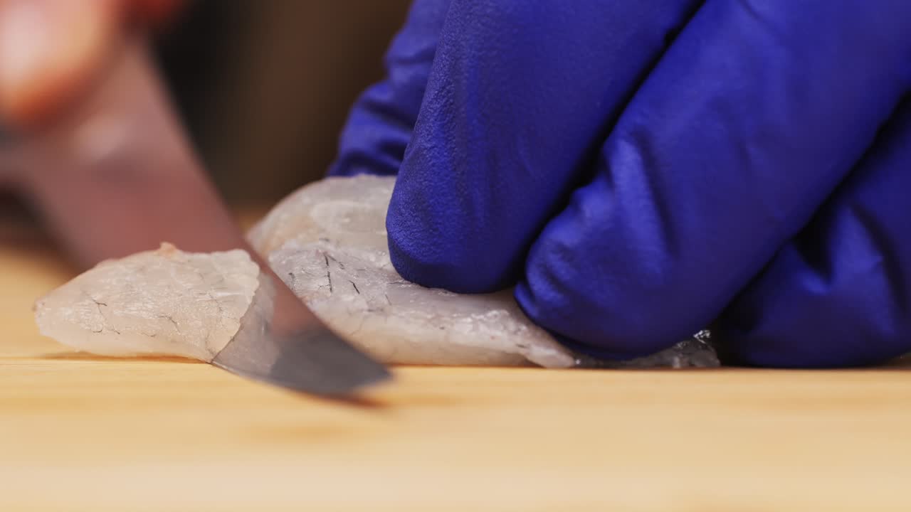 Preparing raw seafood, likely for sushi or sashimi