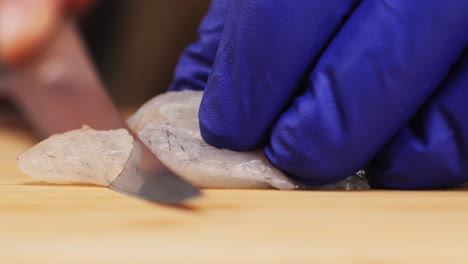 preparing raw seafood, likely for sushi or sashimi