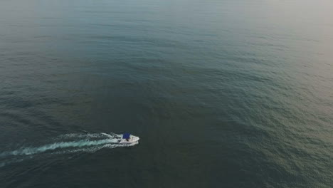 a yacht traveling to the shore at sunset