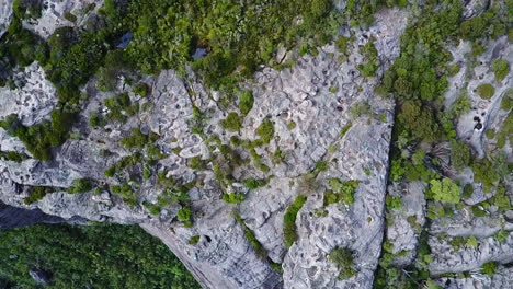Drone-looking-straight-down-while-flying-over-sheer-cliff-face