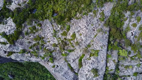 Drohne-Blickt-Direkt-Nach-Unten,-Während-Sie-über-Eine-Steile-Klippe-Fliegt