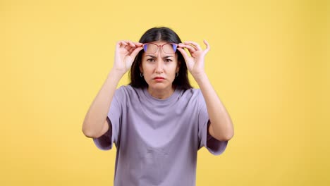 confused young woman peering through her glasses