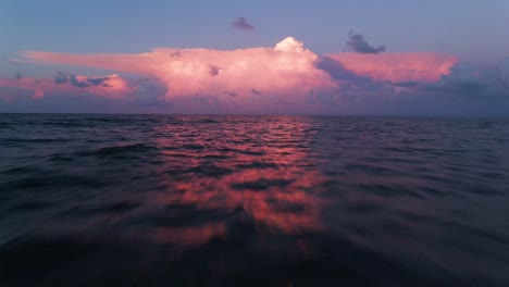 4k volando cerca de las olas en el océano al amanecer