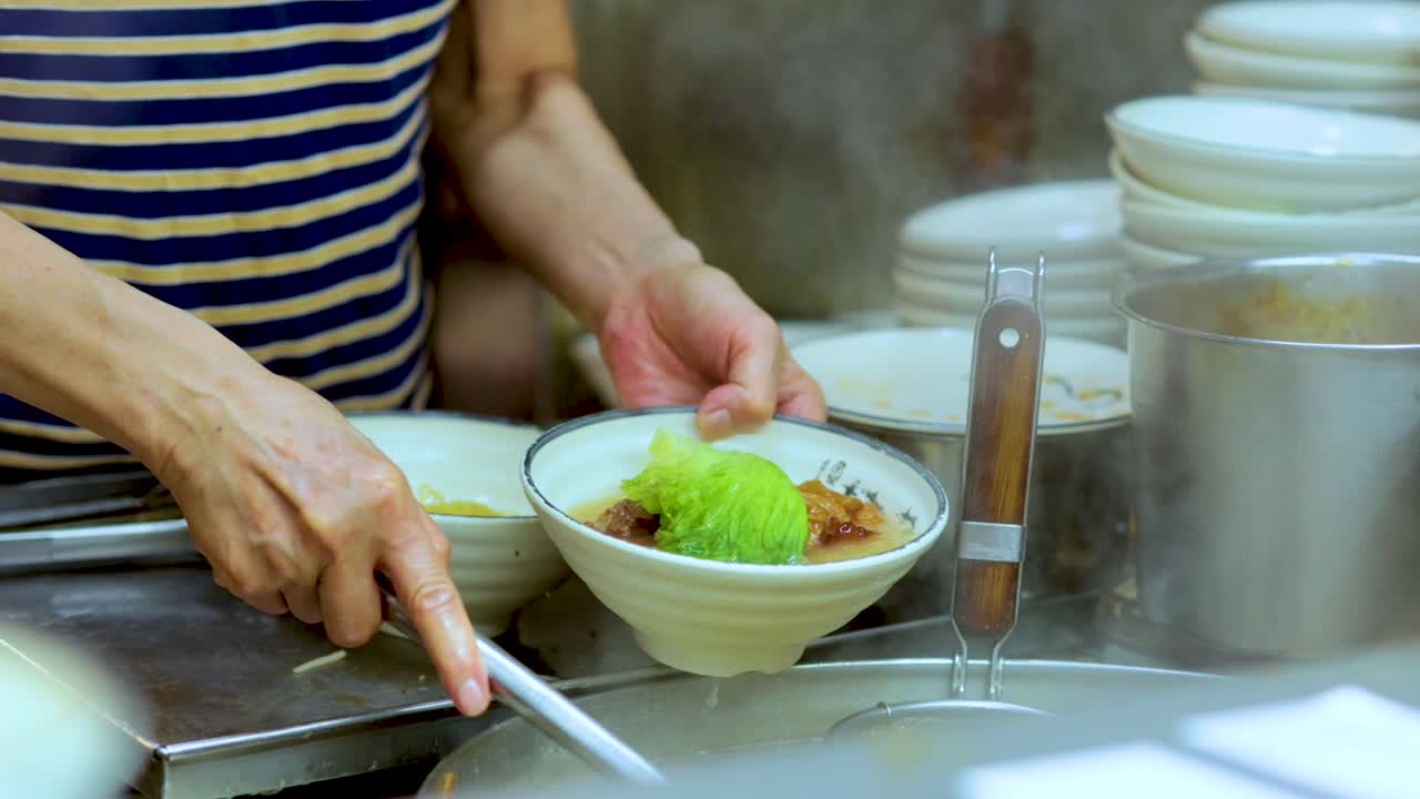 Chef skillfully prepares noodle soup with precision