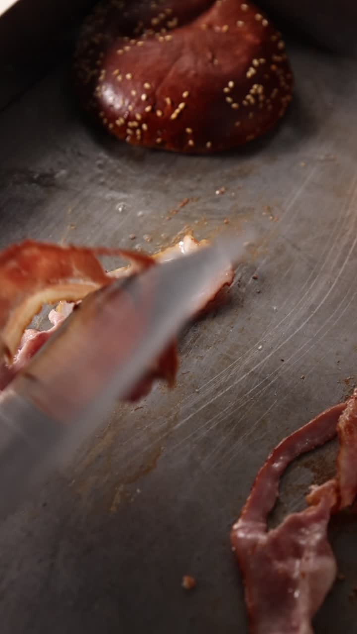 Chef che gira fette di bacon su una piastra calda