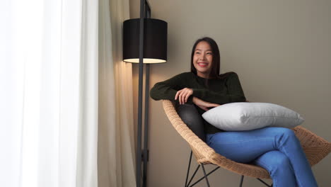 Content-happy-asian-woman-relaxing-at-home-on-a-chaise