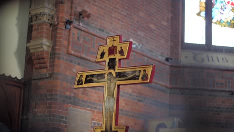 handheld shot of a cross in an old church, with foreground elements